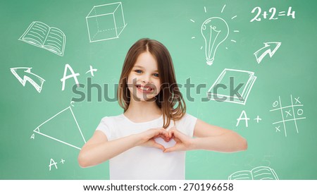 advertising, gesture, charity, education and people - smiling little girl in white blank t-shirt showing heart-shape gesture over green board with doodles background