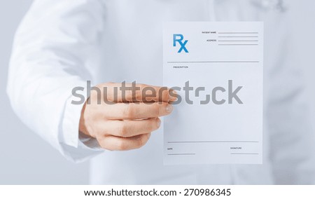 close up of male doctor holding rx paper in hand