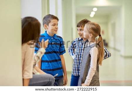 education, elementary school, children, break and people concept - group of smiling school kids talking in corridor