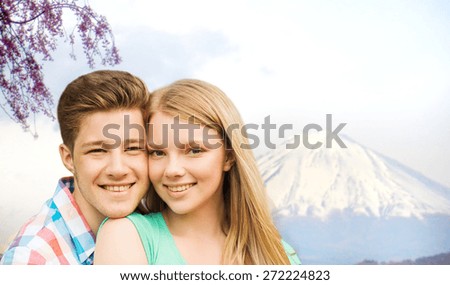 people, vacation, love and travel concept - smiling couple hugging over fuji mountain background