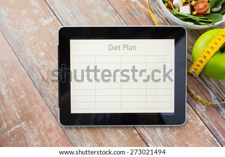 healthy eating, dieting and weigh loss concept - close up of diet plan on tablet pc screen, green apple, measuring tape and salad