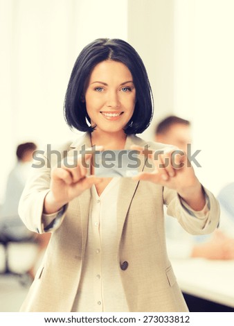 business and bank concept -  smiling businesswoman showing credit card in office