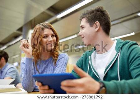 people, education, technology and school concept - happy students with tablet pc computer networking in library