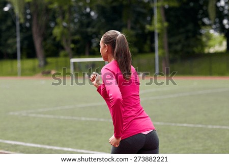 fitness, sport, training, people and lifestyle concept - african american woman running on track outdoors from back