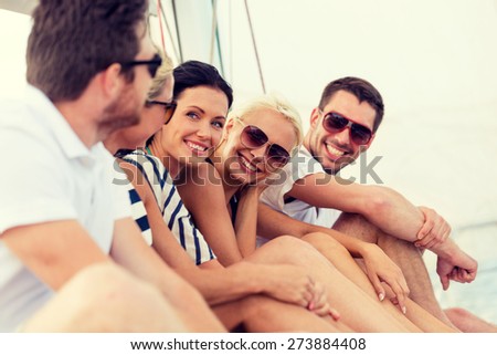 vacation, travel, sea, friendship and people concept - smiling friends sitting on yacht deck