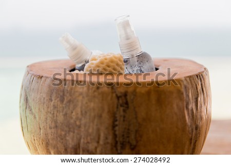 skin care, body care, summer and health concept - bowl with moisturizing spray and wisp at hotel beach or spa