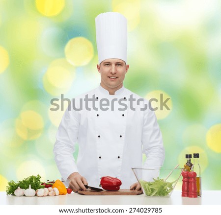 profession, vegetarian, food and people concept - happy male chef cooking vegetable salad over green lights background