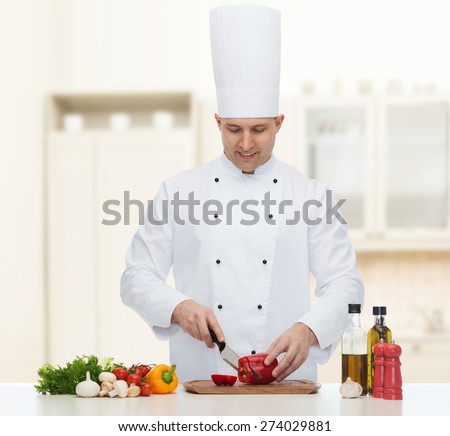 cooking, profession, vegetarian, food and people concept - happy male chef chopping pepper over kitchen background