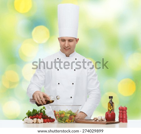 profession, vegetarian, food and people concept - happy male chef cooking salad over green lights background