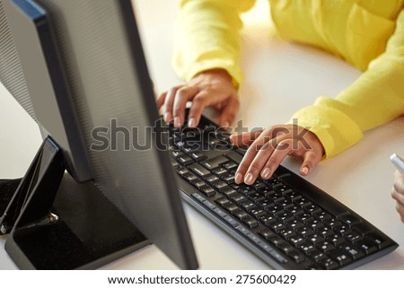 business, technology, school, people and education concept - close up of african american businesswoman or student girl hands with computer sitting at table