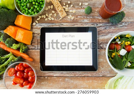 healthy eating, dieting, slimming and weigh loss concept - close up of diet plan on tablet pc screen and vegetables