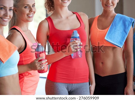 fitness, sport, teamwork, people and lifestyle concept - group of women with bottles of water in gym