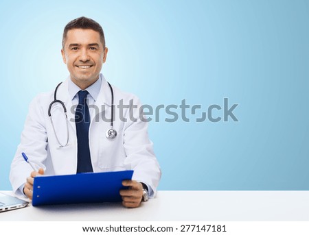 medicine, profession, technology and people concept - happy male doctor with clipboard and stethoscope over blue background