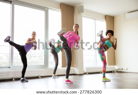 fitness, sport, training, gym and martial arts concept - group of women working out fighting technique in gym