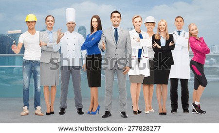 people, profession, qualification, employment and success concept - happy businessman with group of professional workers showing thumbs up over city background