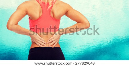 fitness, healthcare and medicine concept - close up of sporty woman touching her back