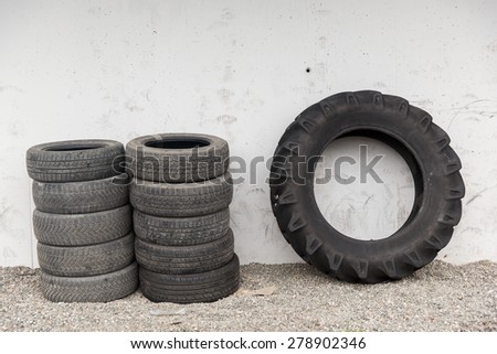 tire, maintenance, service and motor transport concept - close up of wheel tyres stored near wall
