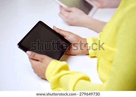 people, technology and internet concept - close up of female hands with tablet pc at table