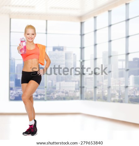 sport, fitness, healthy lifestyle and people concept - sporty woman with orange towel and bottle of water over gym background