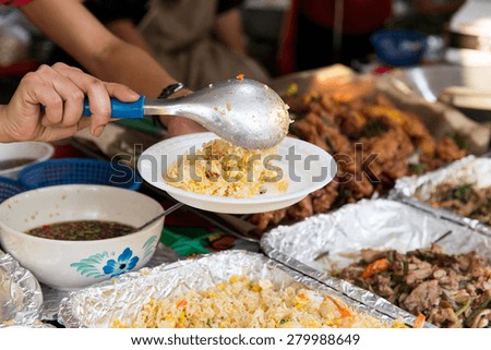 cooking, asian kitchen, sale and food concept - close up of hands with plate, spoon and wok at street market