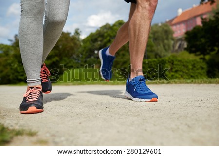 fitness, sport, friendship, people and lifestyle concept - close up of couple running outdoors