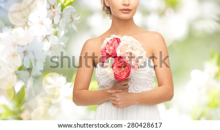 wedding, holidays, people and celebration concept- bride or woman with bouquet of flowers over summer garden and cherry blossom background