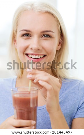 healthy eating, vegetarian food, dieting and people concept - smiling woman drinking juice or shake from glass at home