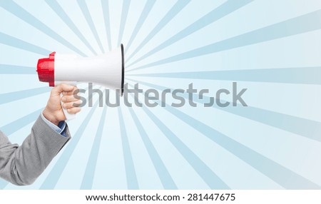 business, people and public announcement concept - close up of male hand in suit with megaphone over blue burst rays background