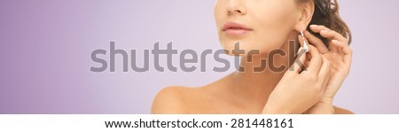 people, beauty, jewelry and accessories concept - beautiful woman with diamond earrings over violet background