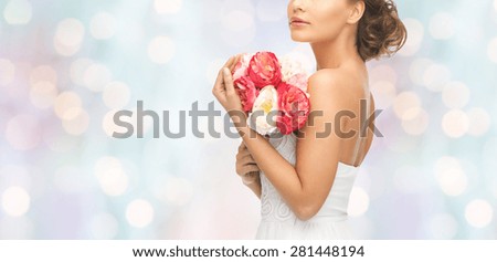 wedding, holidays, people and celebration concept- bride or woman with bouquet of flowers over blue holidays lights background