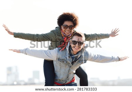 friendship, leisure, international, freedom and people concept - happy teenage couple in shades having fun outdoors