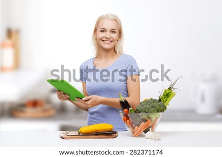 healthy eating, cooking, vegetarian food, technology and people concept - smiling young woman with tablet pc computer and bowl of vegetables over home kitchen background