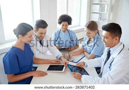 hospital, medical education, health care, people and medicine concept - group of happy doctors with tablet pc computers meeting at medical office