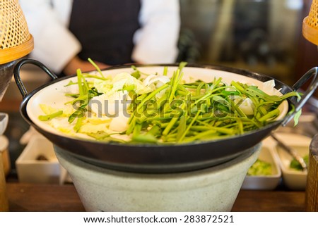 cooking, kitchen and food concept - bowl of green salad or garnish at asian restaurant