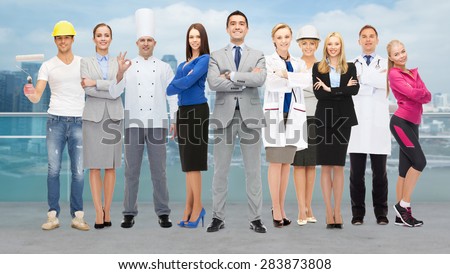 people, profession, qualification, employment and success concept - happy businessman with group of professional workers over city background