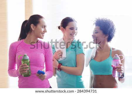 fitness, sport, training, gym and lifestyle concept - group of happy women with bottles of water in gym