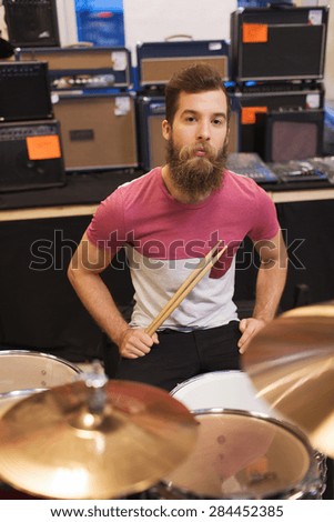 music, sale, people, musical instruments and entertainment concept - male musician playing cymbals at music store