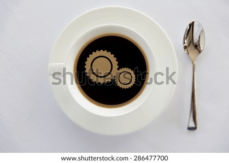 drinks, energetic, efficiency and caffeine concept - cup of black coffee with cogwheel symbol on surface and spoon