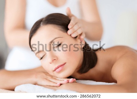 health, beauty, resort and relaxation concept - beautiful woman in spa salon getting face treatment