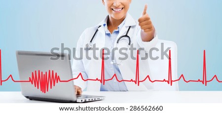 healthcare, medical and technology concept - happy african american female doctor with laptop pc computer showing thumbs up over blue background with red heart shape and cardiogram