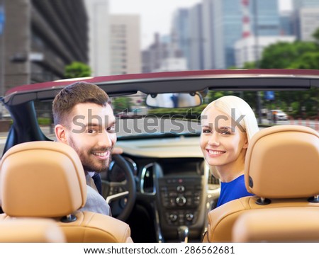 drive, auto transport and people concept - close up of happy couple driving in cabriolet car from back over city street background