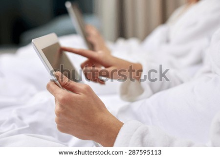 travel, tourism, people and technology concept - close up of woman hands in bathrobe with tablet pc computer at hotel