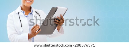 health care, people and medical concept - close up of smiling african american female doctor pointing finger to blank paper sheet on clipboard over blue background