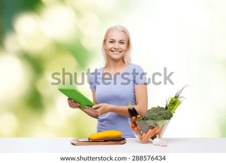 healthy eating, cooking, vegetarian food, technology and people concept - smiling young woman with tablet pc computer and bowl of vegetables over green natural background