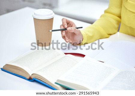 people and education concept - close up of female hands with books and coffee