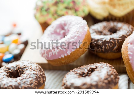 food, junk-food and eating concept - close up of glazed donuts on table