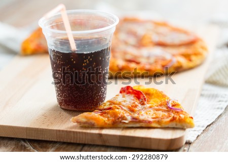 fast food, italian kitchen and eating concept - close up of pizza with cup of cola drink on wooden table