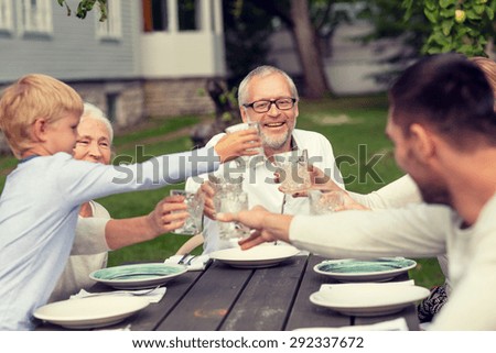 family, happiness, generation, home and people concept - happy family having holiday dinner outdoors