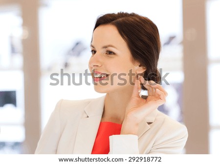 sale, consumerism, shopping and people concept - happy happy women choosing and trying on earrings at jewelry store