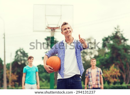 summer vacation, holidays, games, gesture and people concept - group of smiling teenagers playing basketball and showing thumbs up outdoors